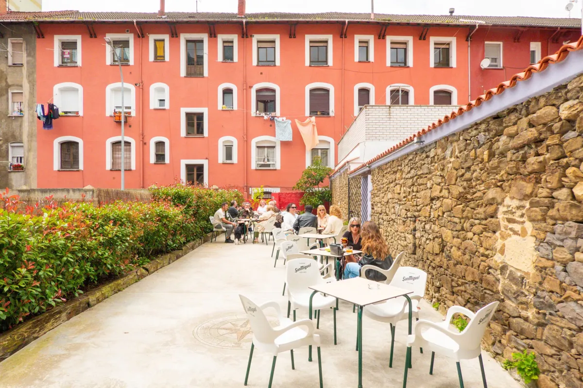 Gente en mesas de la terraza exterior a la hora del aperitivo