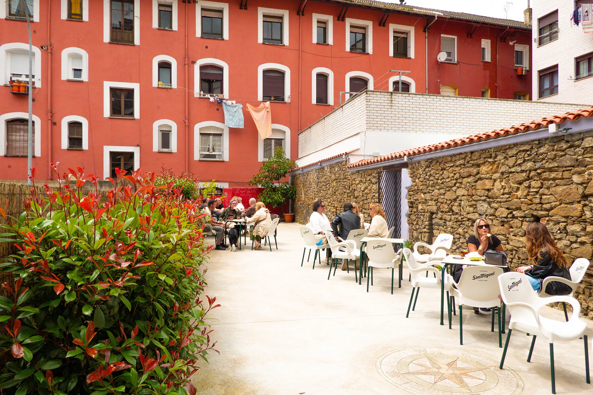 Mesas de la terraza exterior con gente disfrutando del vermú.